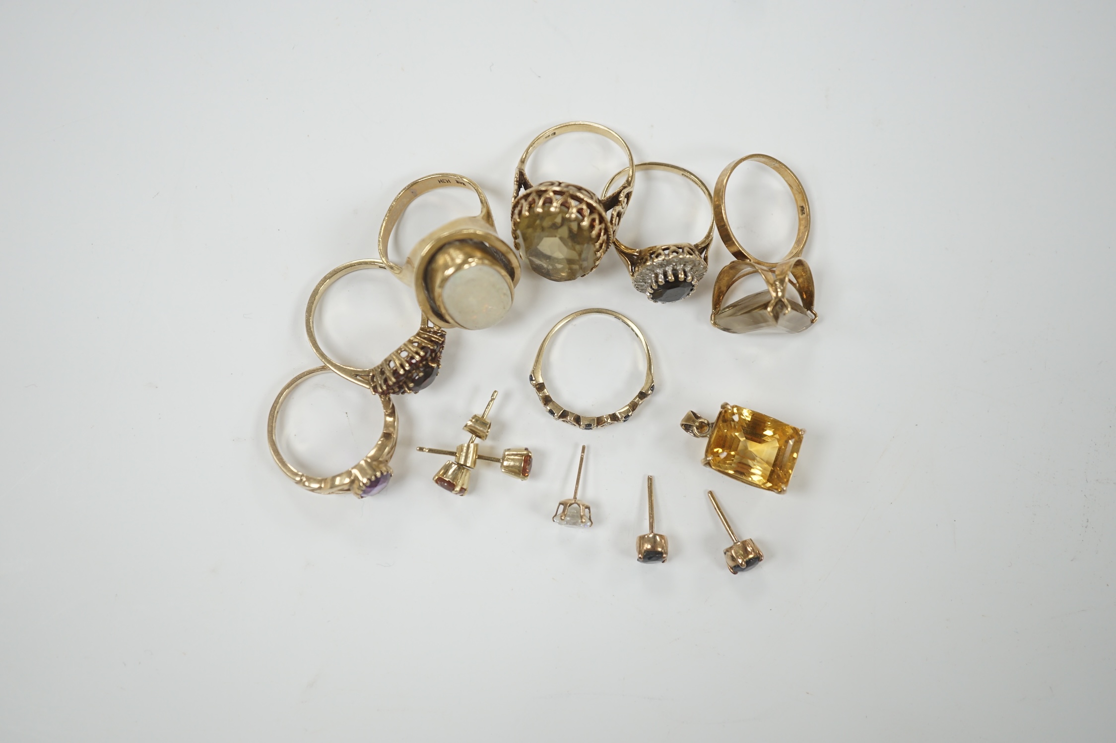 Seven assorted modern 9ct and gem set rings, including garnet cluster, white opal and amethyst, gross weight 26.2 grams, together with a pendant and assorted ear studs.